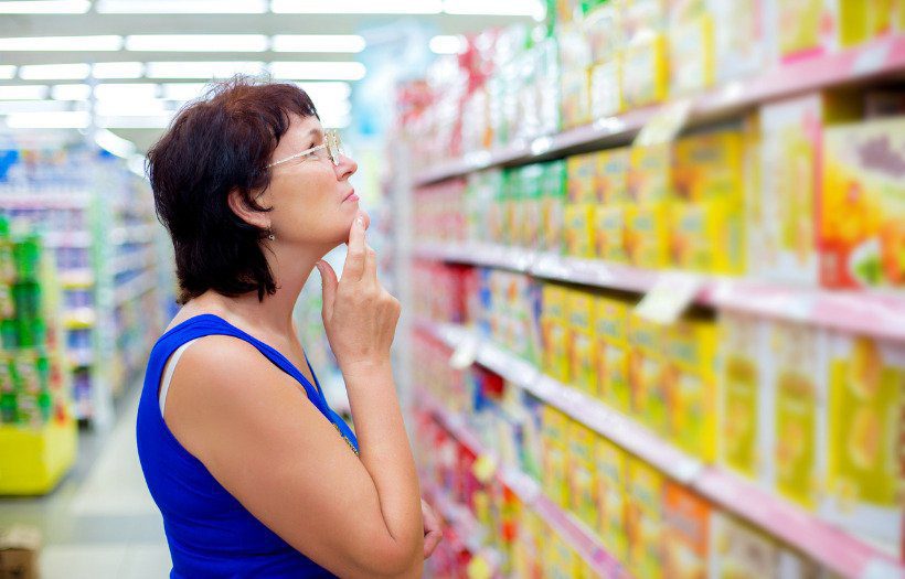 woman looking at products on a supermarket shelf