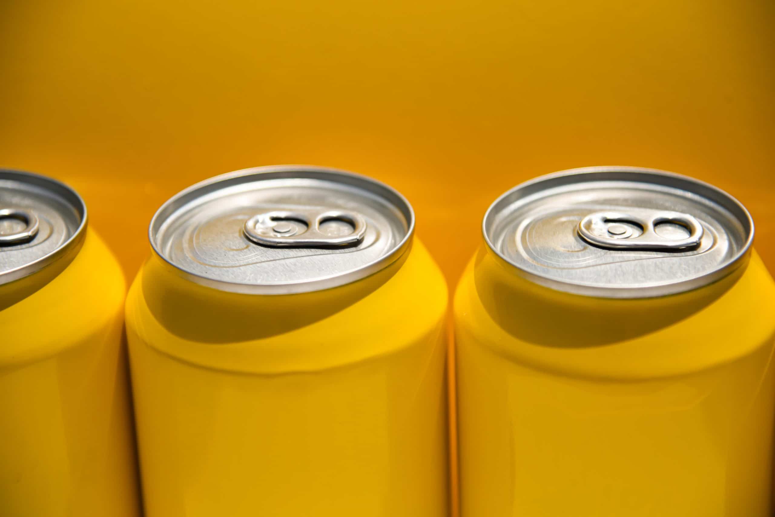 yellow drinks cans with a yellow background