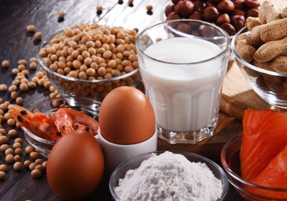 eggs, milk, salmon, prawns and nuts all displayed on a table